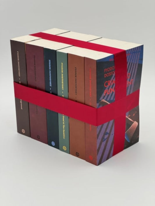 Set of books bound together with a red ribbon on a gray background