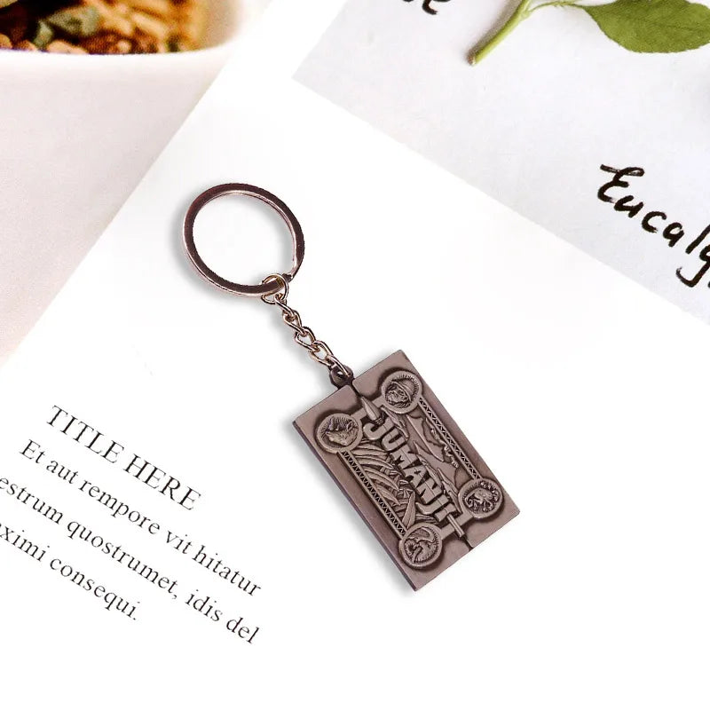 Bronze Jumanji keychain with decorative text on a white background