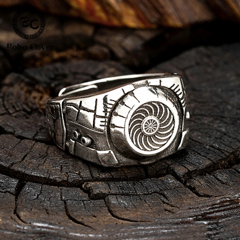Silver ring with intricate design on a wooden surface
