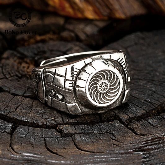 Silver ring with intricate design on a wooden surface