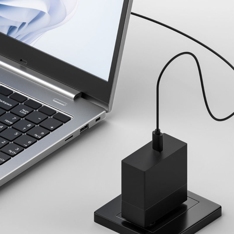 Black USB hub connected to a laptop on a light gray background