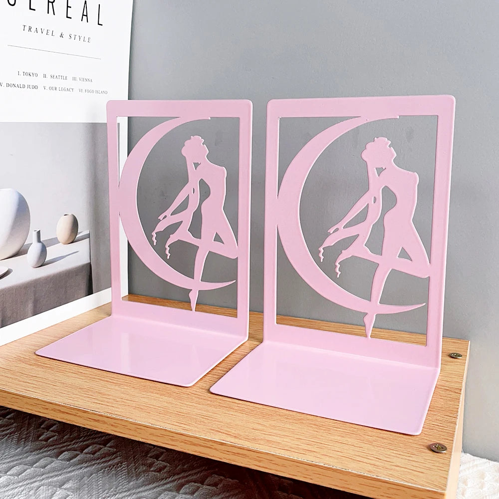 Pink bookends with a silhouette design on a wooden surface.