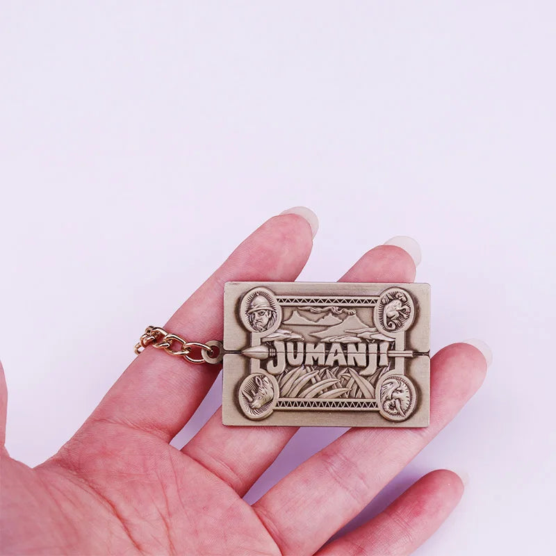 Hand holding a 'Jumanji' themed keychain against a white background