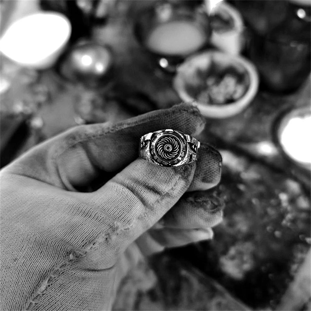 Hand holding a decorative ring with a blurred background