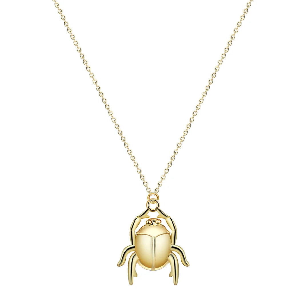 Gold beetle pendant necklace on a white background