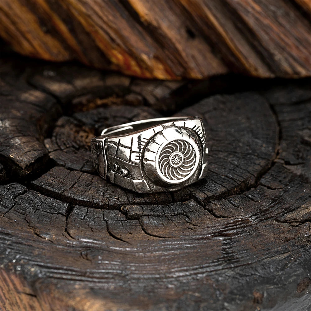 Silver ring with a detailed design on a wooden surface