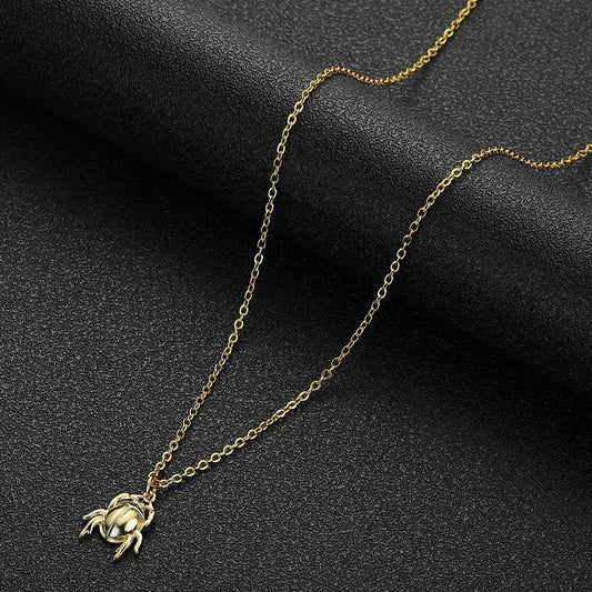 Gold crab pendant necklace on a dark background