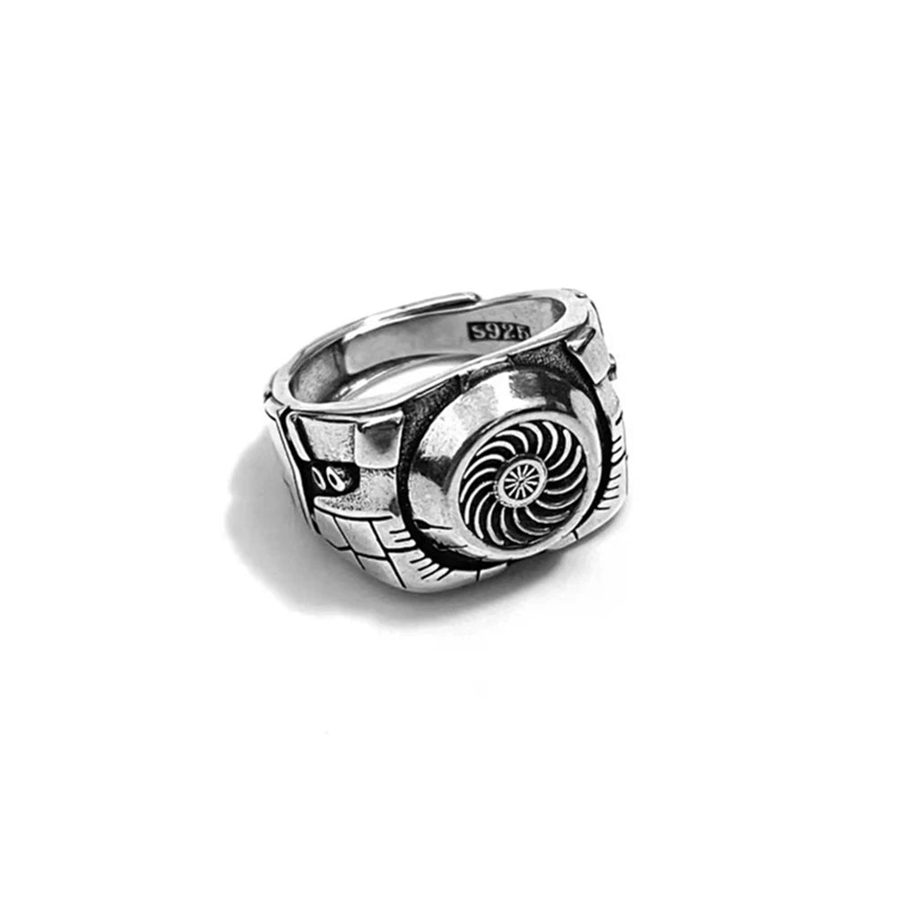 Silver ring with intricate design on a white background