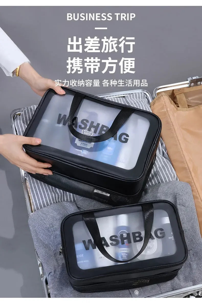 Person holding a black travel bag with 'WASHBAG' branding on a gray surface.