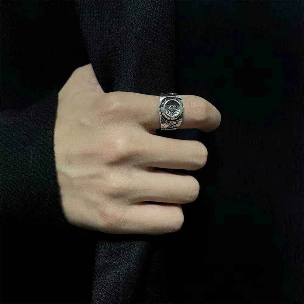 Hand wearing a silver ring with a black background