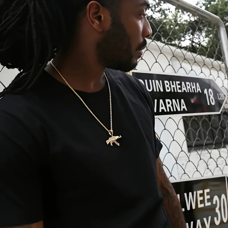Man wearing a gold AK47 pendant necklace rope chain, standing in front of a fence with signs.