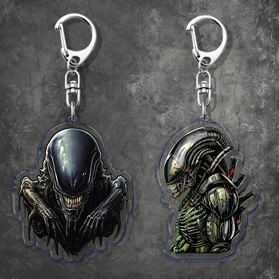 Two alien-themed keychains on a textured gray background