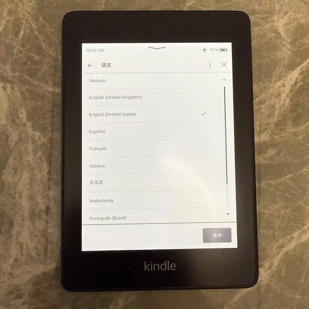 Kindle device displaying language selection menu on a marble surface