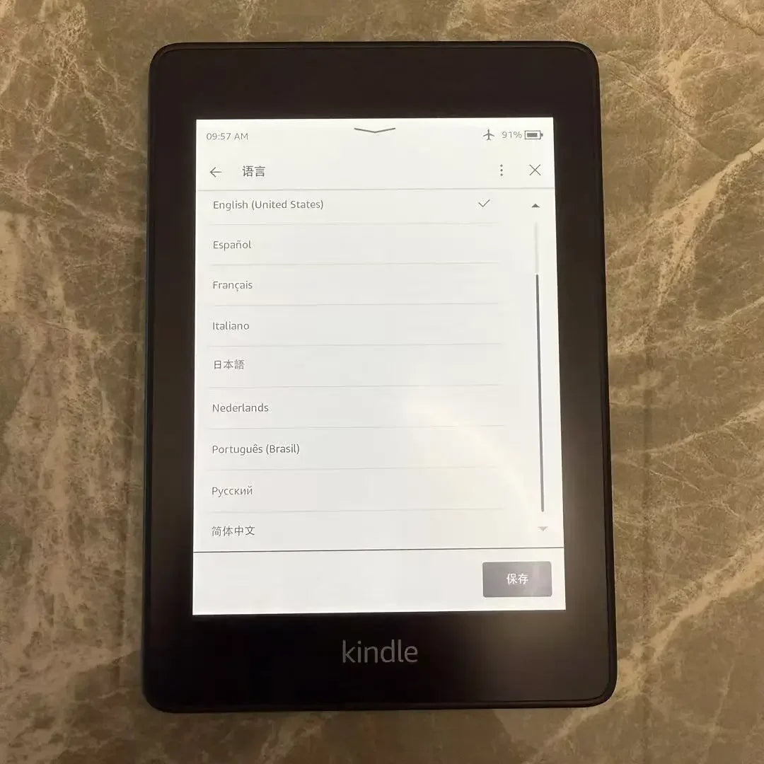 Kindle device displaying language selection menu on a marble surface