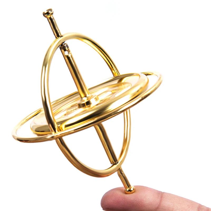 Gold metal anti-gravity gyroscope spinner balanced on a finger over a white background