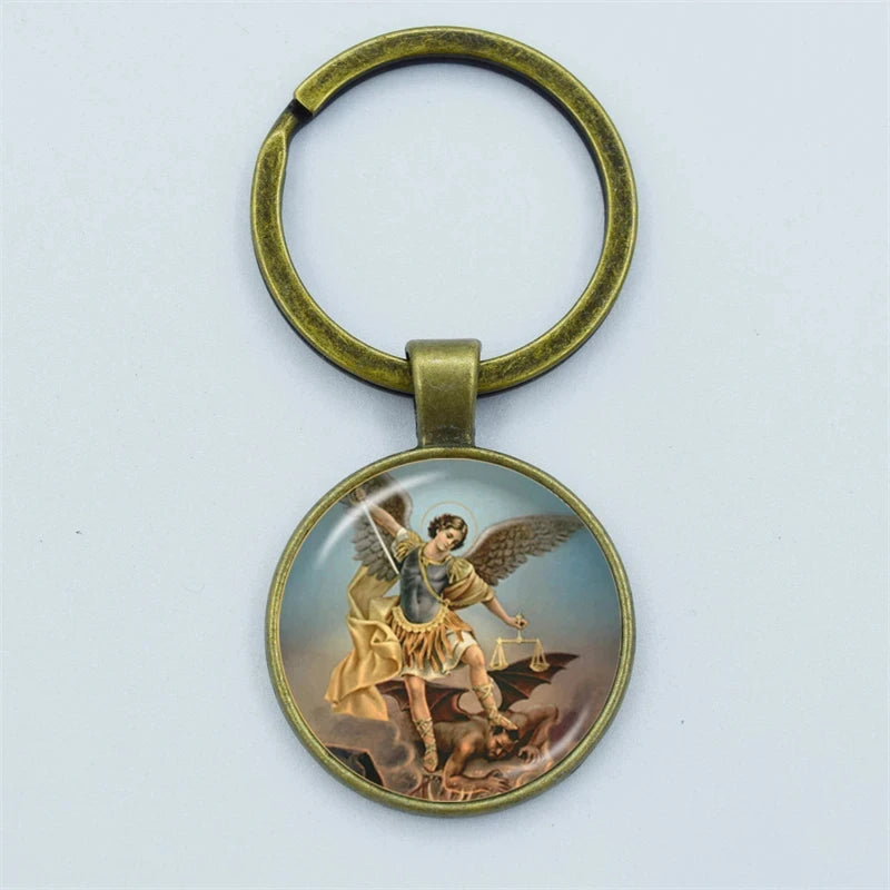 Keychain with an angel holding a sword and scales on a white background
