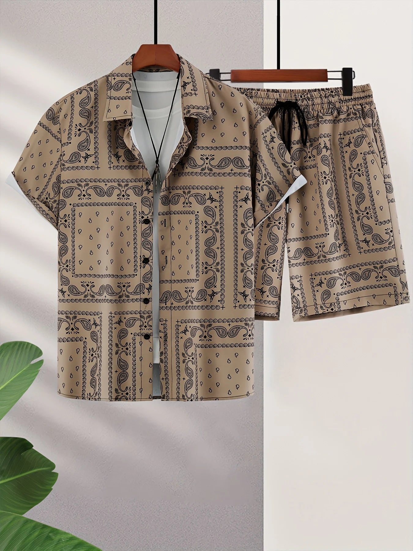 Beige paisley patterned bandana shirt and shorts set on a hanger with a light gray background.
