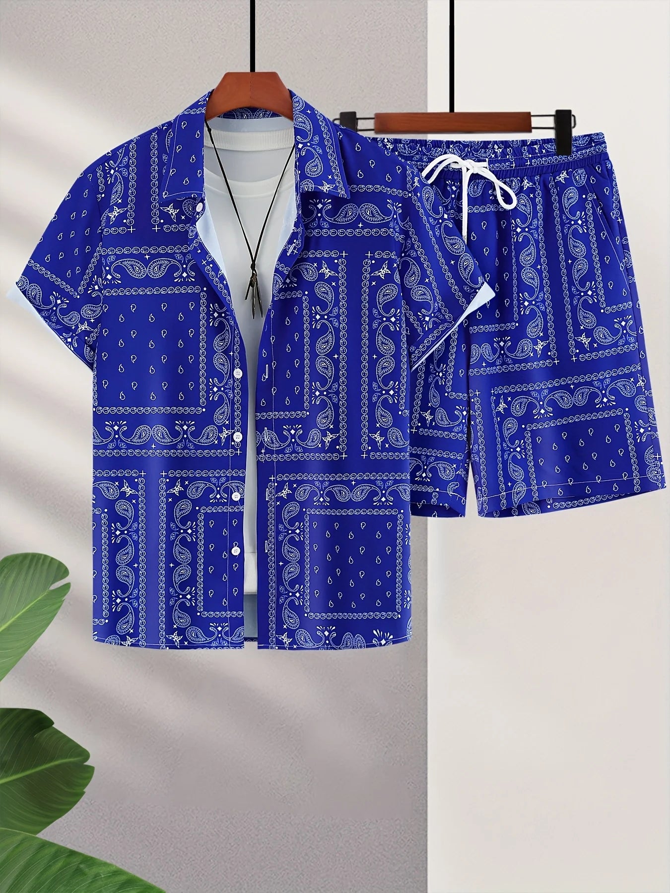 Blue bandana patterned shirt and shorts set on a hanger against a light background.