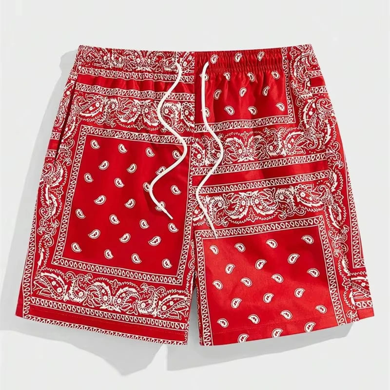 Red and white paisley patterned bandana shorts on a light gray background.