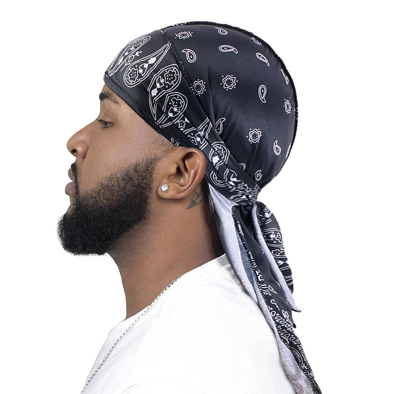 Man wearing a black bandana durag with white patterns on a white background