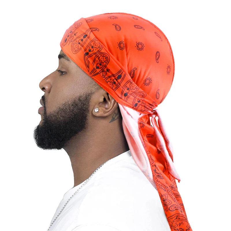 Man wearing an orange patterned headscarf on a white background
