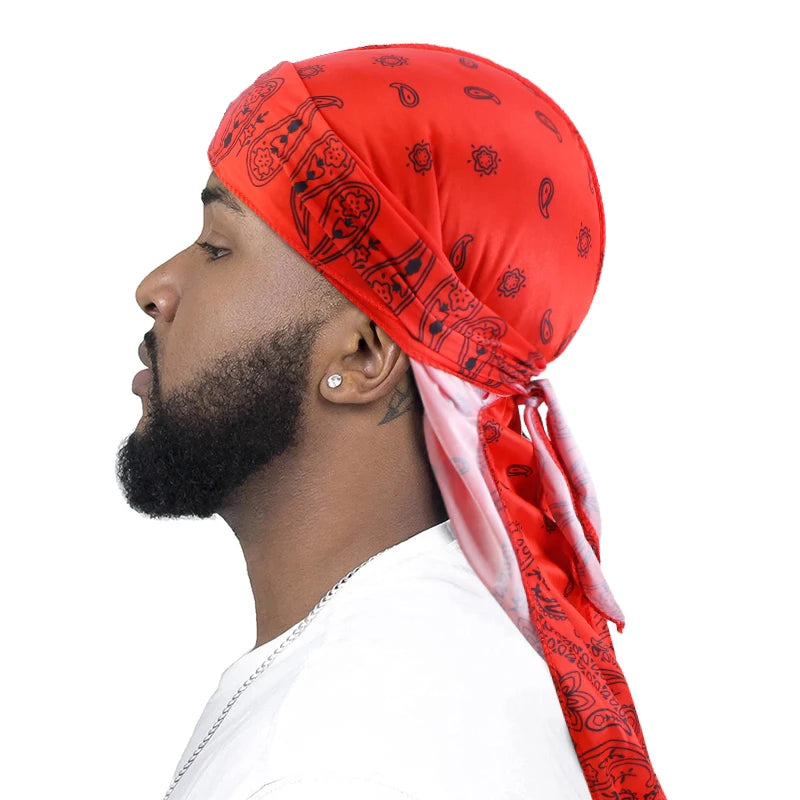 Man wearing a red bandana durag with black paisley bandanna pattern on a white background