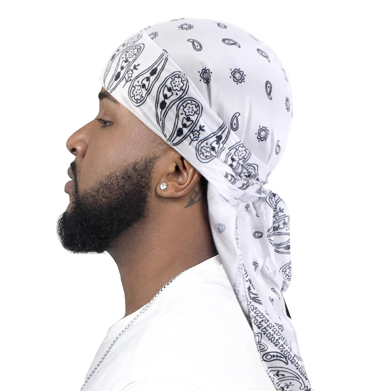 Man wearing a white satin bandana durag with black patterns on a white background