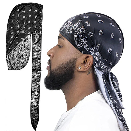 Man wearing a black bandana paisley pattern durag with white pattern on black over a white background