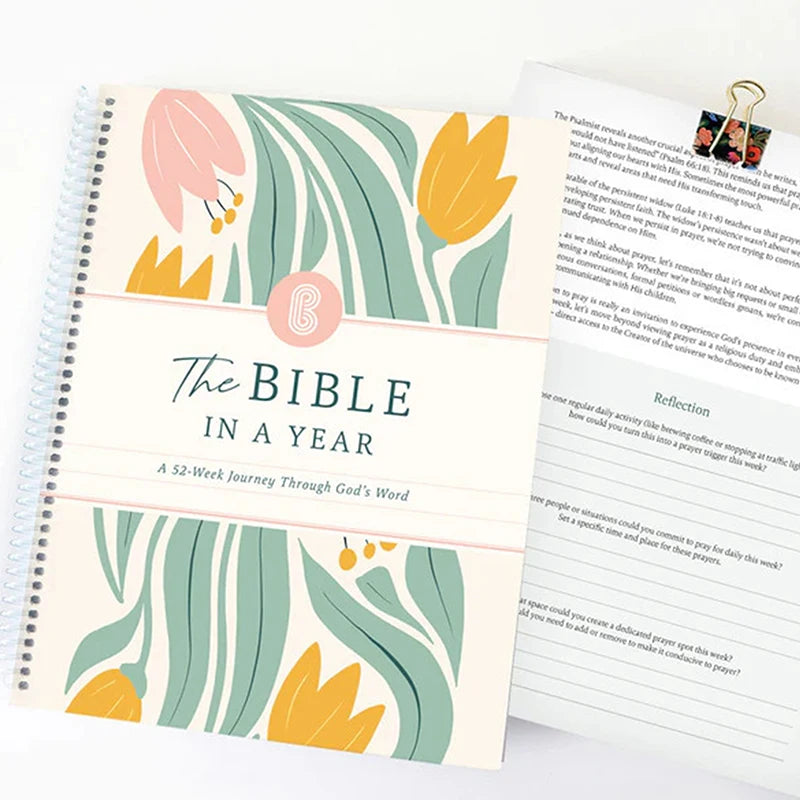 Spiral-bound book titled 'The Bible in a Year' with floral design on cover