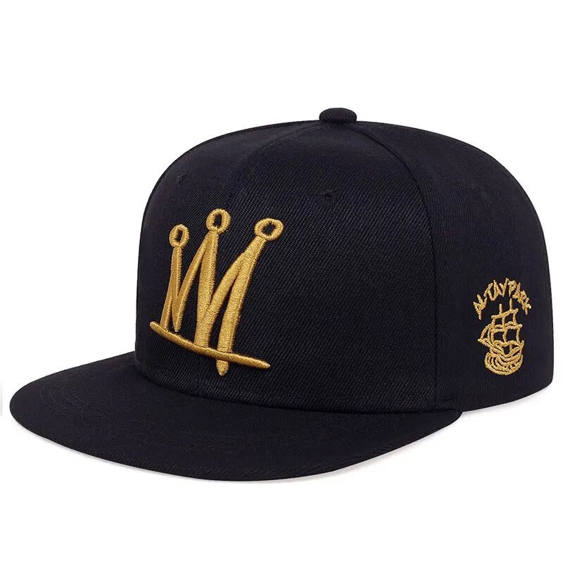 Black cap with gold embroidered crown designs on a white background
