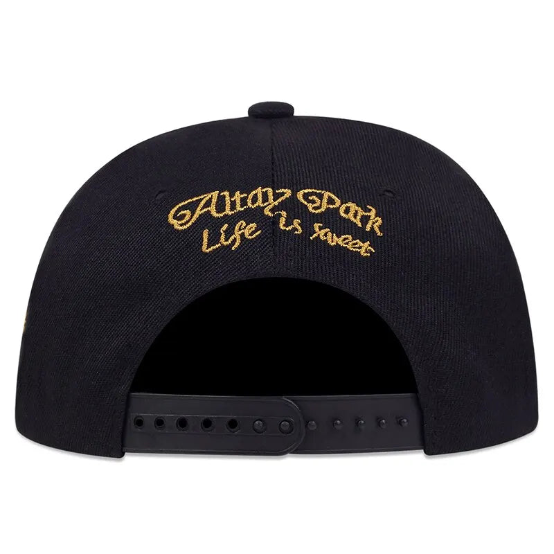 Black cap with gold embroidered text on a white background