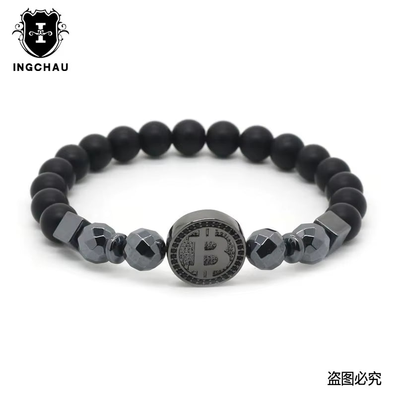 A black bead bracelet with a central Bitcoin emblem, flanked by darker and lighter beads, branded by Hematite Healing & Crypto Creations.