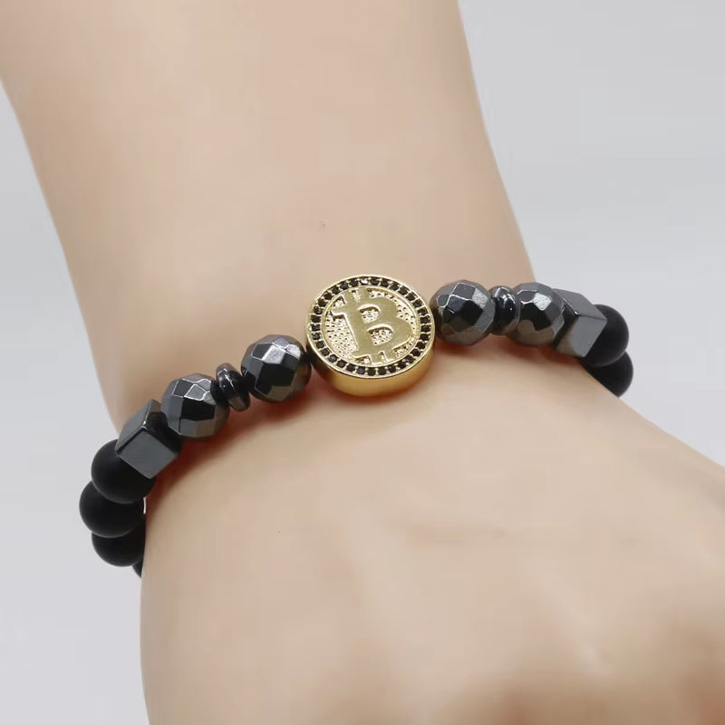 Gold and black Bitcoin Energy Bead Bracelet by Hematite Healing & Crypto Creations being displayed on wrist.
