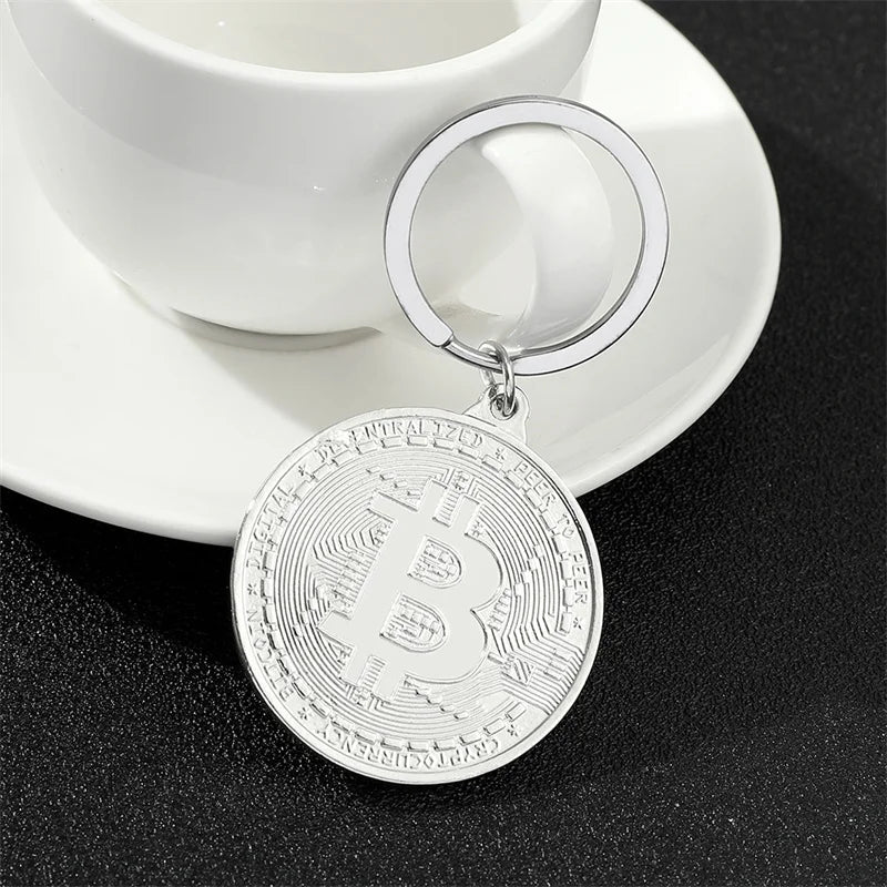 Bitcoin keychain on a saucer with a white cup in the background