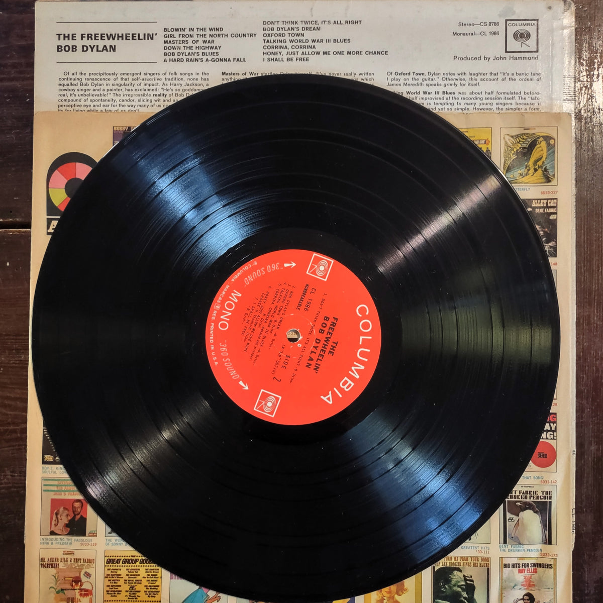 Image of The Freewheelin' Bob Dylan Vinyl Record featuring the back cover with the paper insert and wax record.