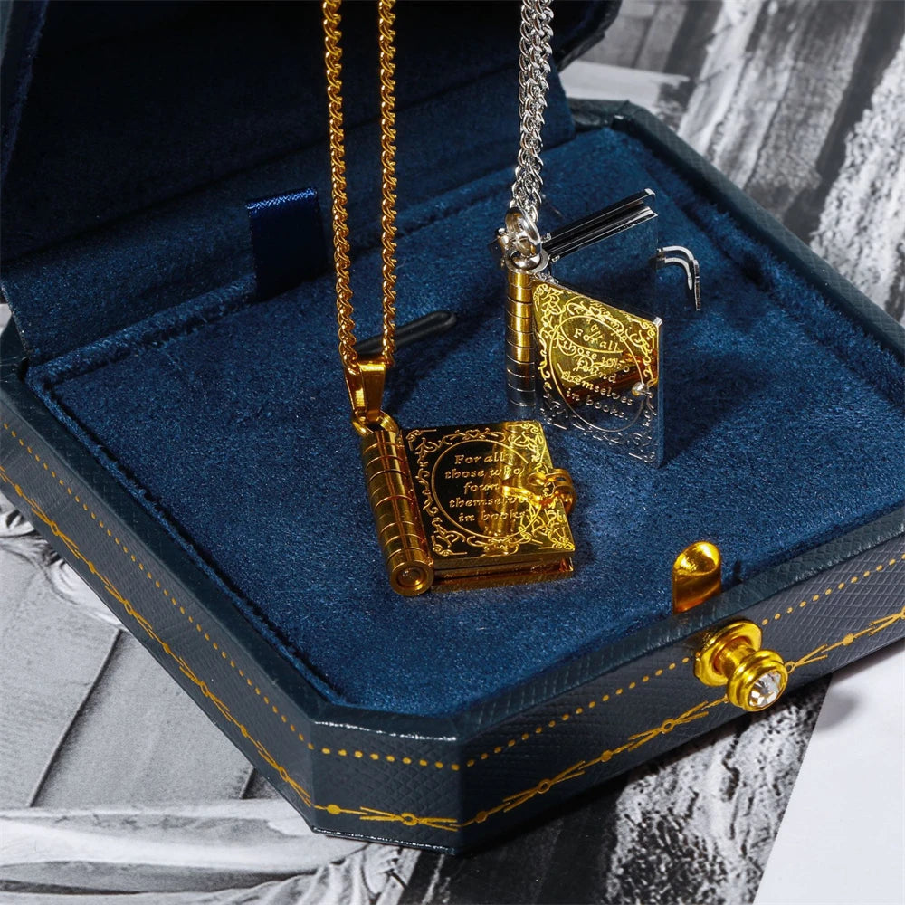 Gold and silver necklace with book design pendant in a blue jewelry box.