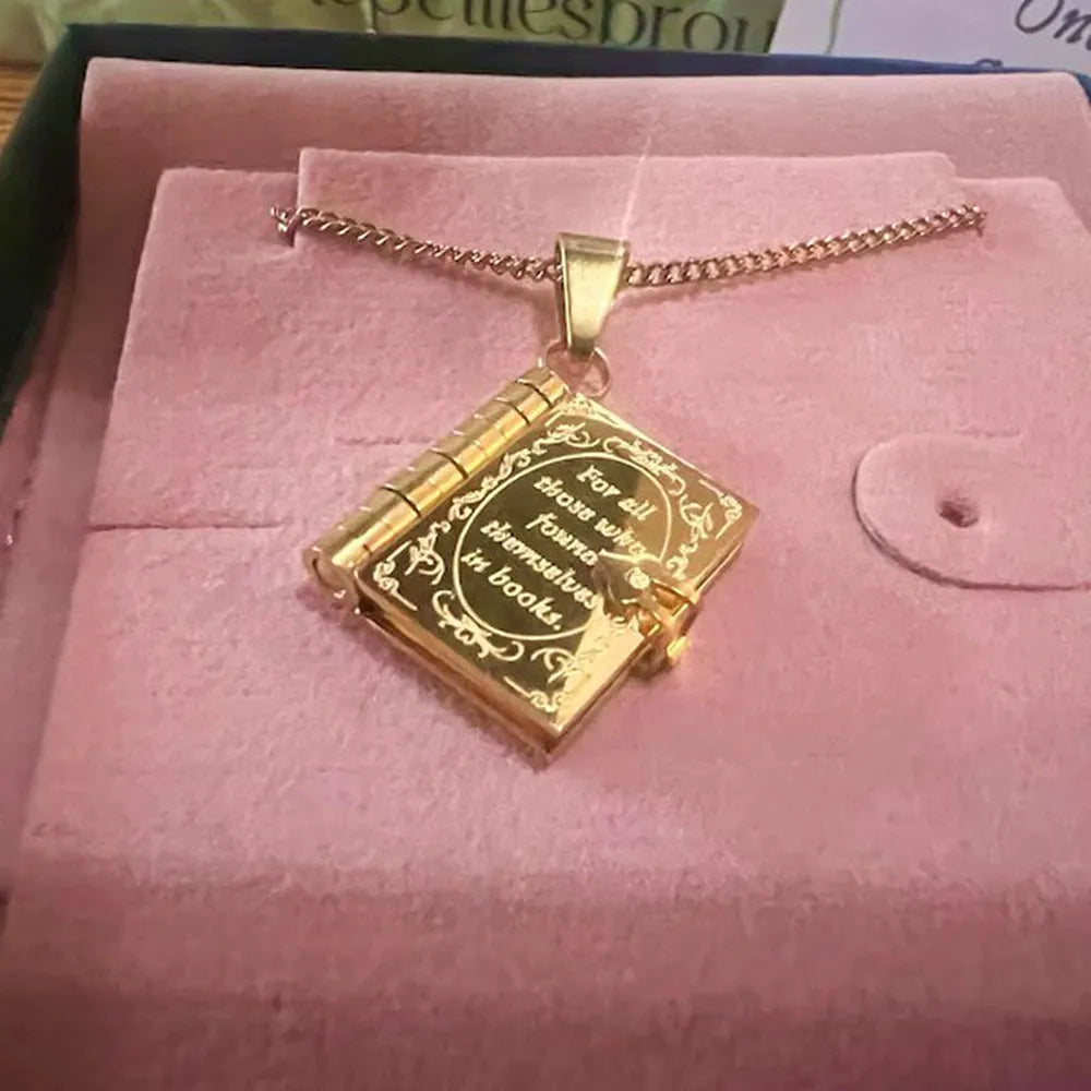 Gold book-shaped pendant necklace on pink velvet