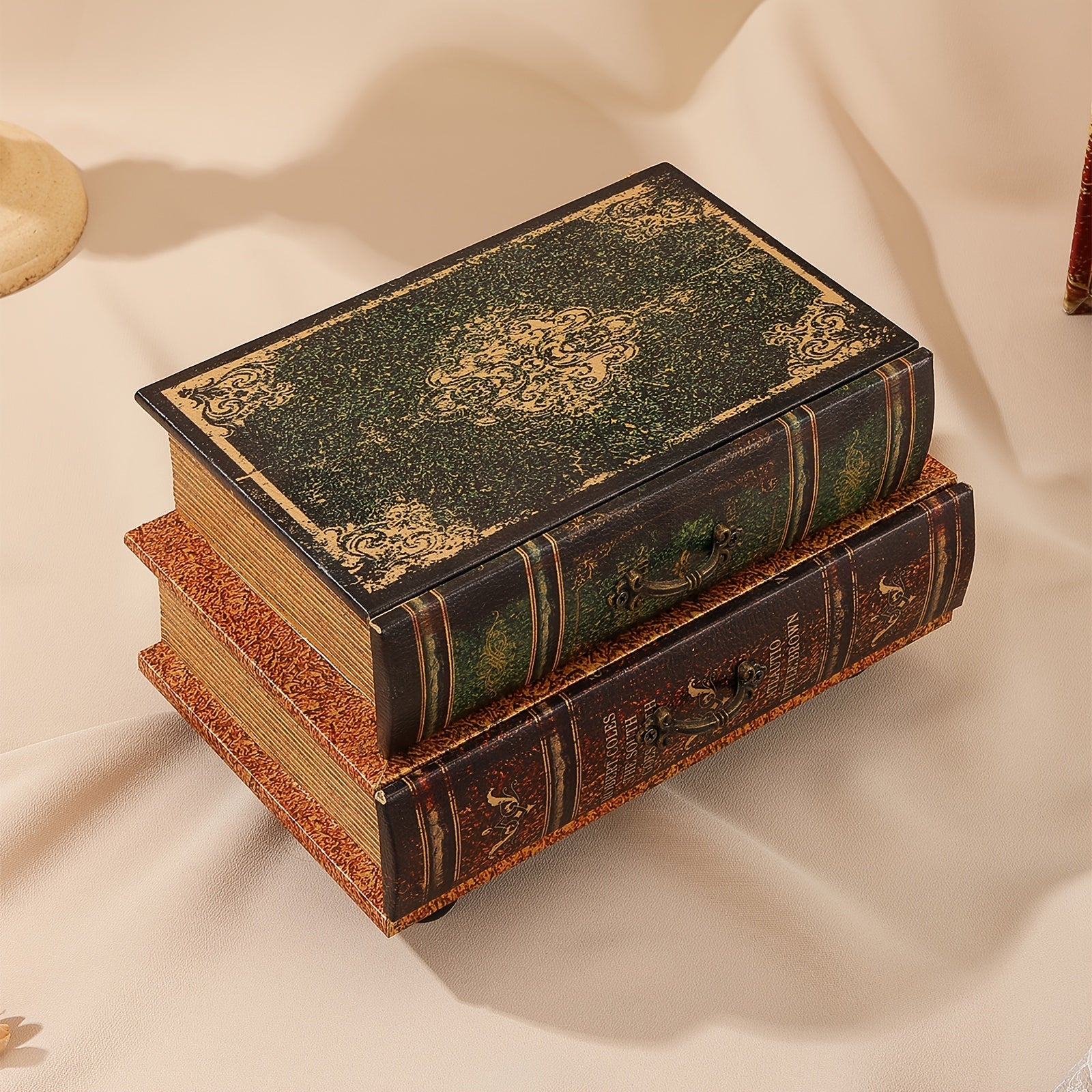 Stack of decorative books with ornate covers on a beige fabric background
