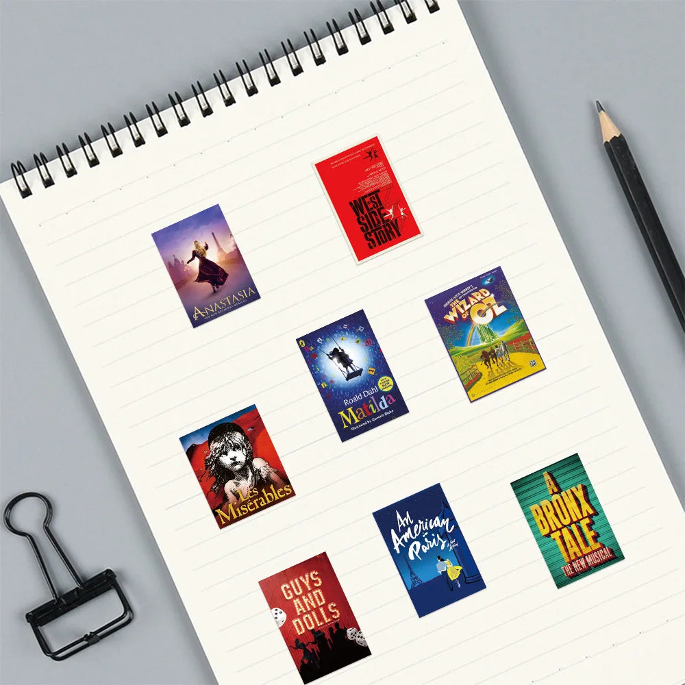 Notebook with theater play posters on a gray surface