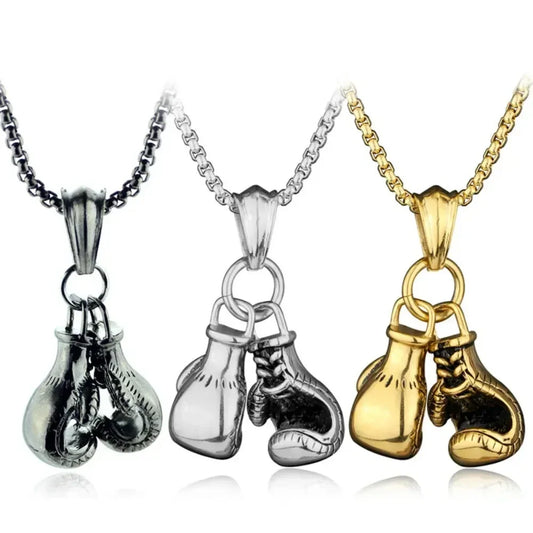Three boxing glove pendants on chains in silver, gold, and black.