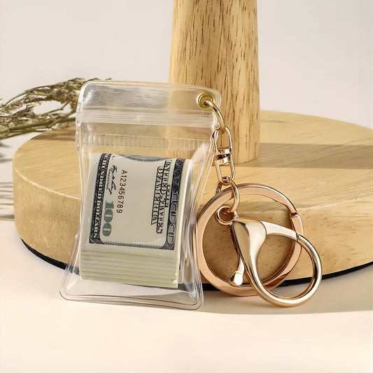 Keychain with clear pouch containing a dollar bill on a wooden surface