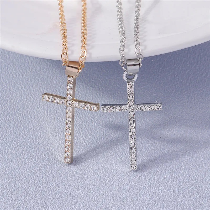 Two cross-shaped necklaces on a light blue background