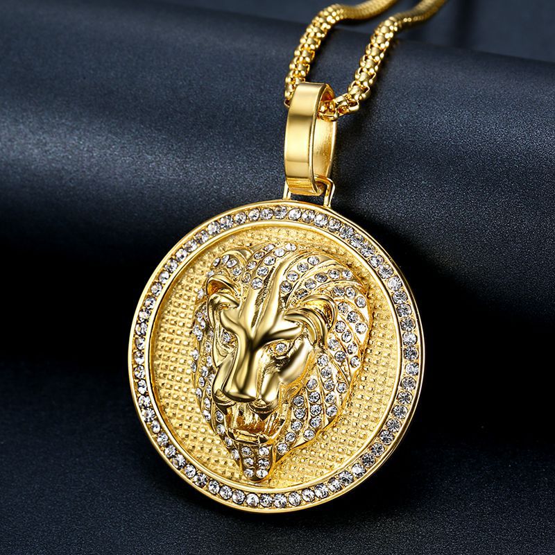Gold lion pendant necklace with clear stones on a dark fabric background