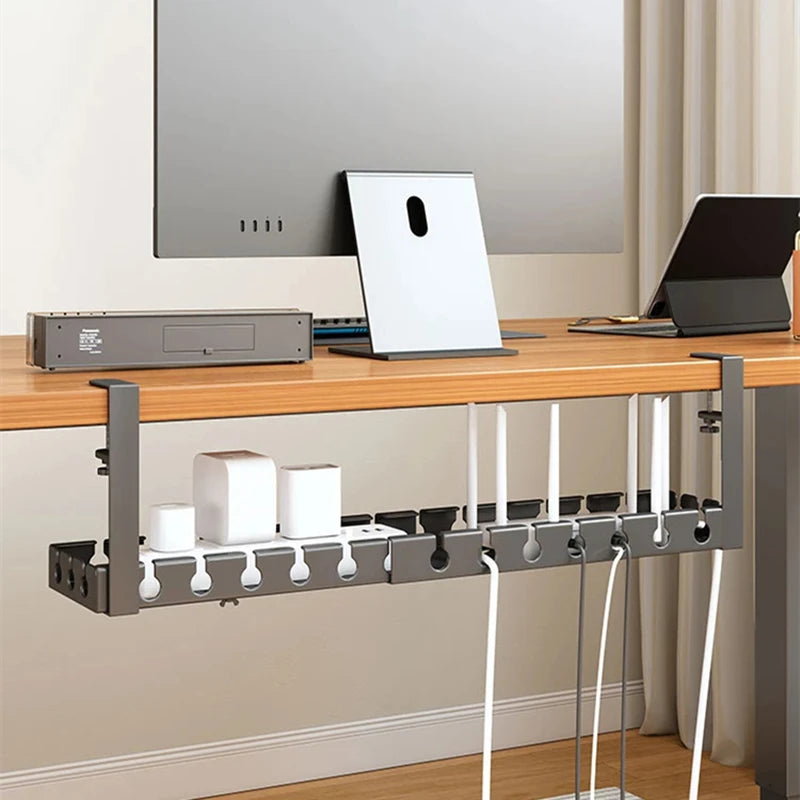 Desk with cable management system, laptop, monitor, and tablet in a home office setting.