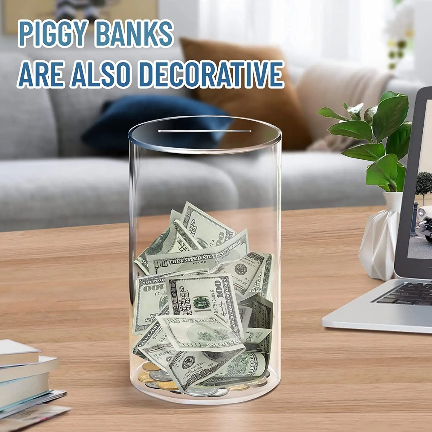 Decorative acrylic piggy bank filled with money on a table with a laptop and books in the background.