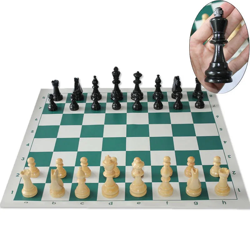Chessboard with black and white chess pieces on a green and white checkered board.