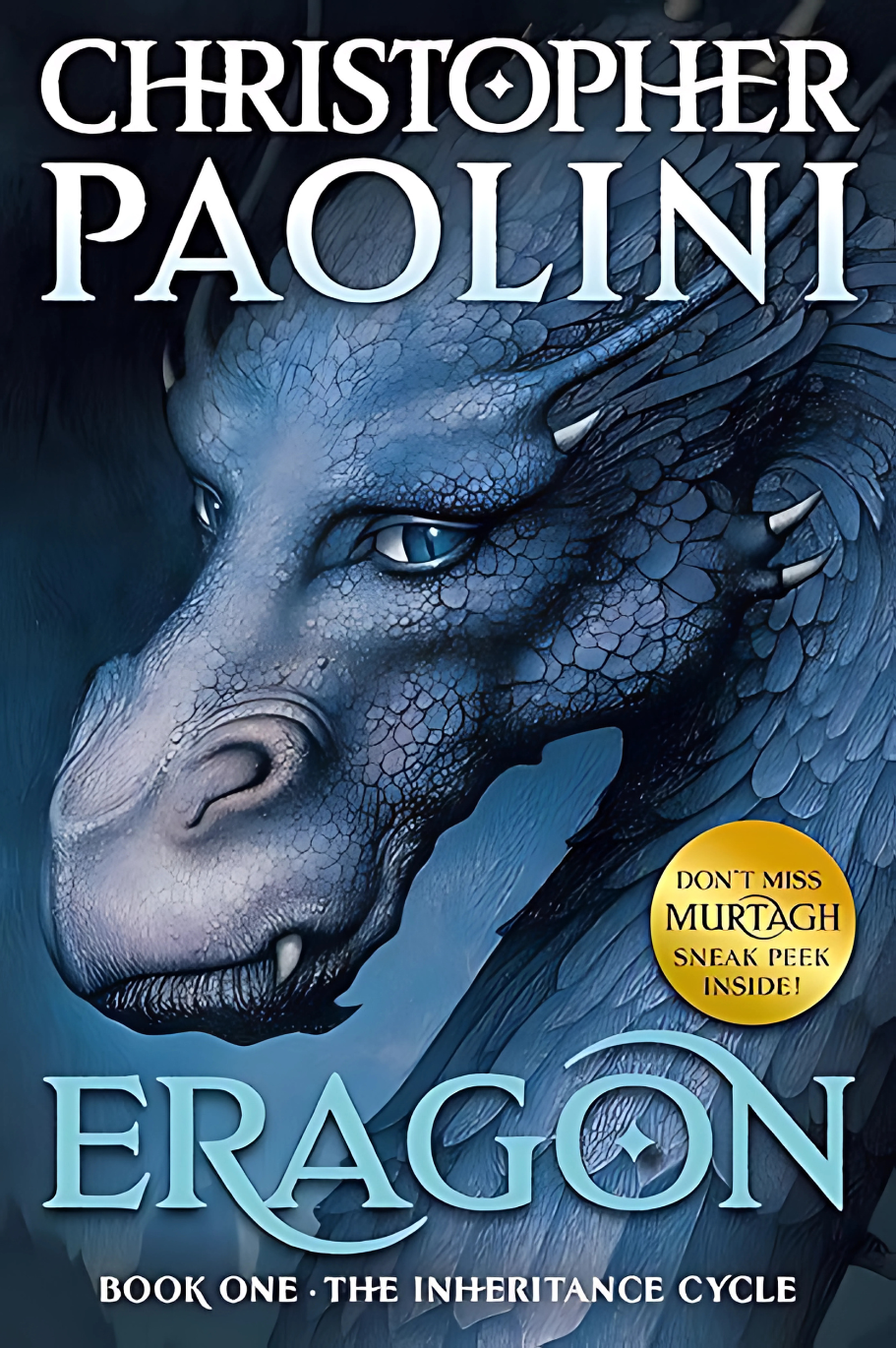 Book front cover of the book 'Eragon' from "Christopher Paolini Inheritance Cycle Box Set Eragon-Eldest-Brisingr-Inheritance" featuring a colored drawing of a blue dragon head from an angled view.