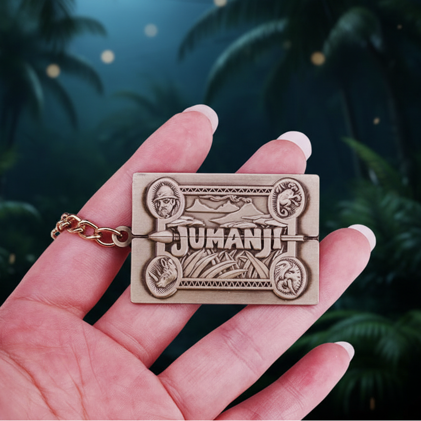 Hand holding a 'Jumanji' themed keychain against a nocturnal jungle background.