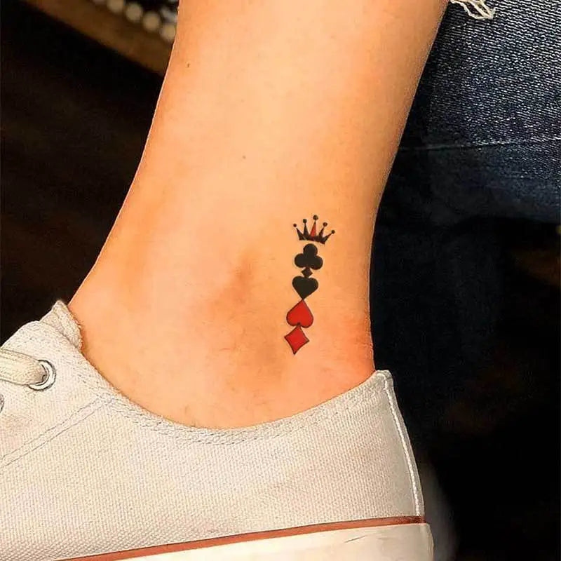 Small tattoo of a card suit symbol on a person's ankle, wearing a white low-top shoe.