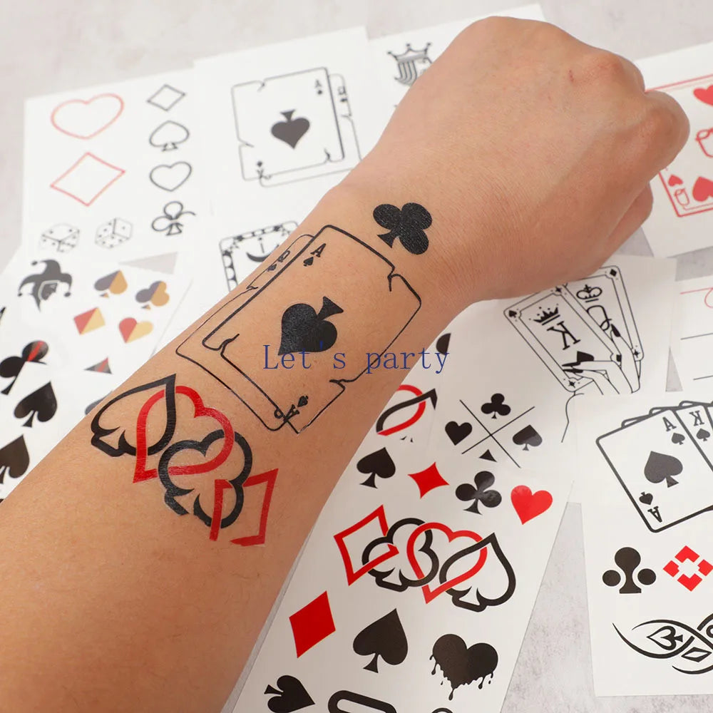 Temporary tattoos of playing card suits on a person's arm with cards in the background.